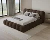 A modern bedroom with a large bed, large windows with curtains, and a rug. Voir les images du produit