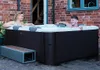A couple relaxing in an outdoor hot tub. Produktbild-Vorschau