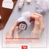 Hands crafting a small felt gingerbread house with white fluffy trim, surrounded by craft supplies like felt, thread, and stuffing. Produktbild-Vorschau