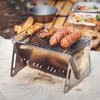 Silberner tragbarer Campinggrill mit Hähnchen und Würstchen über offener Flamme im Freien Anteprima dell’immagine prodotto