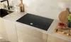 A modern induction cooktop integrated into a kitchen countertop, with sink and cabinets visible. Anteprima dell’immagine prodotto