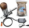 A collection of items for an electric smoking chamber, including a smoke generator, wood chips, a lighter, and a power adapter. Náhled obrázku produktu