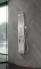 A modern stainless steel shower panel mounted on a gray tiled wall. Podgląd zdjęcia produktu