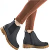 A close-up shot of a person wearing blue Chelsea boots and brown pants. Produktbild-Vorschau
