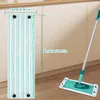 A mop head and a mop with its head attached to the handle are shown on a wooden floor in front of kitchen cabinets. Dimensions are indicated with text. Produktbild-Vorschau