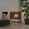A modern living room corner with a fireplace, firewood storage, and a large potted plant. Produktbild-Vorschau