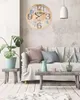 A living room scene with a clock on the wall, a sofa, and a coffee table. Voir les images du produit