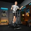 A man is exercising on a black elliptical trainer in a home gym setting. Produktbild-Vorschau
