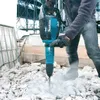 A person is using a Makita demolition hammer to break up concrete debris on a construction site. Anteprima dell’immagine prodotto