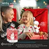 A grandmother and granddaughter are sitting together, looking at each other and smiling, with Christmas decorations in the background. There are also Christmas-themed products in the foreground. Produktbild-Vorschau