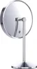 A close-up, rear view of a silver, round makeup mirror on a stand, against a white background. Produktbild-Vorschau