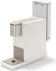 A white and light gold Tchibo Qbo coffee machine with a transparent water tank. Produktbild-Vorschau