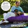 A man and a dog are sitting on a large purple cushion outdoors. Anteprima dell’immagine prodotto