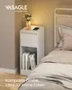 A white nightstand with books and a glass of water is next to a bed. Produktbild-Vorschau