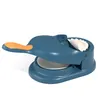 A blue and orange dumpling maker with a white dumpling inside, set against a white background. Podgląd zdjęcia produktu