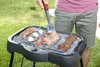 A person is grilling food on an electric grill outdoors. Náhled obrázku produktu