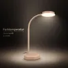 A desk lamp with a flexible neck and a circular light source, shown on a dark background with a lit area around its base. Produktbild-Vorschau