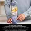 A person is holding a portable blender filled with fruit and yogurt. Náhled obrázku produktu