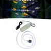 A USB aquarium air pump with tubing and an air stone, shown against a white background. The top portion of the image shows a blurry aquarium with fish. Podgląd zdjęcia produktu