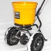 A yellow spreader with black wheels sits in the snow. Produktbild-Vorschau
