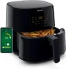 A black Philips Airfryer with a smartphone showing an app interface next to it. Produktbild-Vorschau