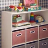 A white shelving unit filled with children's toys and storage boxes, set against a blue and white checkered wallpaper. Anteprima dell’immagine prodotto
