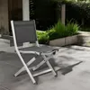A folding chair is placed on a patio. Produktbild-Vorschau