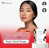 A woman is shown with product packaging for Kojie San Kojic Acid Soap. Anteprima dell’immagine prodotto