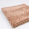 A folded brown blanket with a chevron pattern is shown on a white background. Podgląd zdjęcia produktu