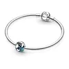 A silver Pandora bracelet with two charms: one is a clip charm with the Pandora logo, and the other is a blue and white globe charm. Podgląd zdjęcia produktu