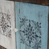 Close-up of two cabinet doors with decorative stencil patterns. Podgląd zdjęcia produktu