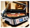 A close-up shot of a grill with two pizzas on it, in a kitchen setting. Anteprima dell’immagine prodotto