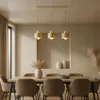 A dining room setting with a table, chairs, and a pendant light fixture. Produktbild-Vorschau