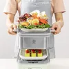 A person wearing an apron is holding a steaming pot with seafood and vegetables. Produktbild-Vorschau