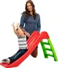 A woman is watching a child slide down a red and green slide. Anteprima dell’immagine prodotto
