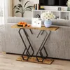 A console table with a rustic wood top and black metal legs is placed behind a sofa in a living room setting. It is decorated with a bowl of oranges, two framed pictures, and a blue vase with white flowers. Podgląd zdjęcia produktu