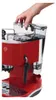 A hand is shown adding water to the reservoir of a red espresso machine. Podgląd zdjęcia produktu