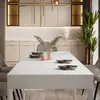A dining table set in a modern dining room with kitchen cabinets in the background. Náhled obrázku produktu