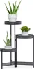 A black metal plant stand with three tiers, holding three potted plants. Náhľad obrázku produktu