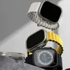 Multiple Apple Watch Ultra accessories are displayed on a textured surface with a gray background. Náhled obrázku produktu