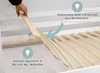 A hand is installing wooden slats onto a bed frame.