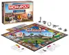A Monopoly board game box and board are displayed, along with game pieces and cards. Produktbild-Vorschau