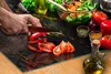 A person is chopping vegetables on a cutting board. Náhľad obrázku produktu