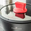 A close-up shot of a pot lid with a red handle and the brand logo visible. Podgląd zdjęcia produktu