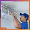 A technician is installing or repairing an air conditioning unit. Produktbild-Vorschau