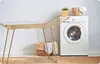 A gold folding drying rack is shown next to a white washing machine in a laundry room. Produktbild-Vorschau