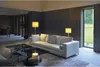 A modern living room with a sofa, coffee table, and lamps, with a view of a garden through a large window. Voir les images du produit