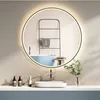 A modern bathroom vanity with a round illuminated mirror, sink, and faucet. Voir les images du produit