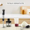 A kitchen counter with a hand blender and its accessories, including a chopper, a measuring cup with liquid, and a whisk attachment with whipped cream. Produktbild-Vorschau