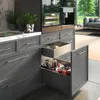 A close-up view of kitchen cabinets with drawers open, revealing cookware inside. The scene is brightly lit, highlighting the modern design of the kitchen. Produktbild-Vorschau